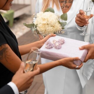 lesbian-couple-accepting-gifts-from-guests-their-wedding_23-2150835728